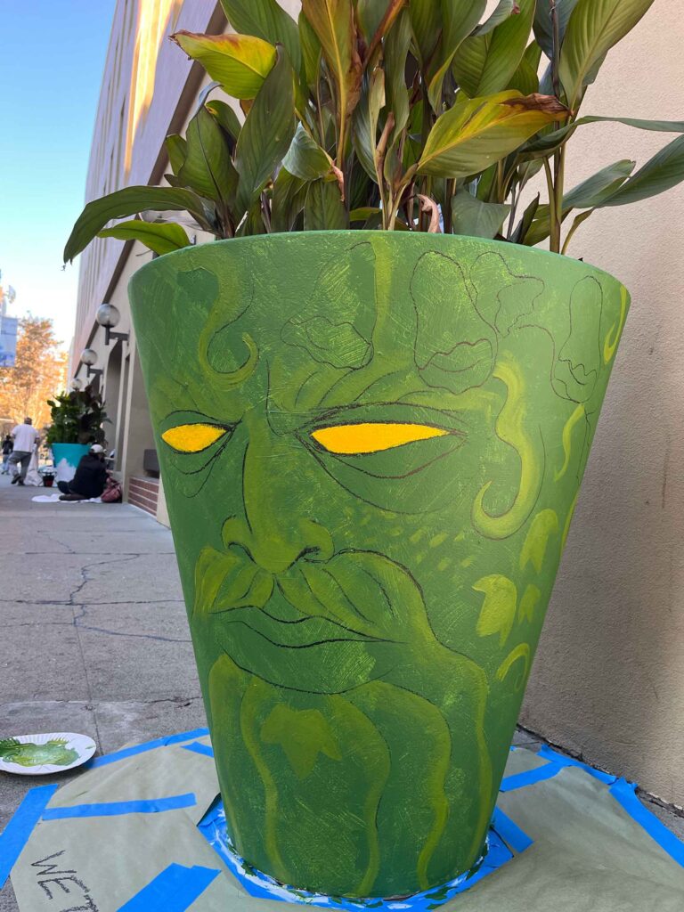 Day 1 (first layers of mostly green paint) of Green Man of South First painted planter